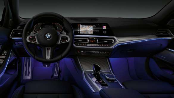 BMW 3 Series Saloon (G20), Ambient light. Front view of the driver's cockpit of the BMW 3 Series Saloon (G20) with by Ambient light blue illuminated legroom.