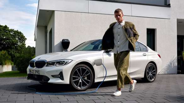 Plug-in hybrid BMW 3 Series Saloon 2021 G20 three-quarter front view charging Plug-in hybrid BMW 3 Series Saloon 2021 G20 three-quarter front view charging with model