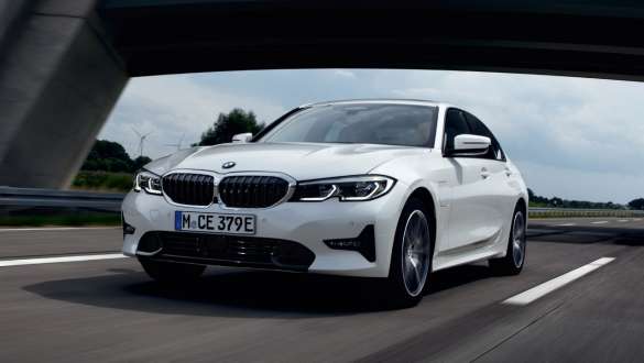 Plug-in hybrid BMW 3 Series Saloon 2021 G20 three-quarter front view driving Plug-in hybrid BMW 3 Series Saloon 2021 G20 three-quarter front view driving on the street