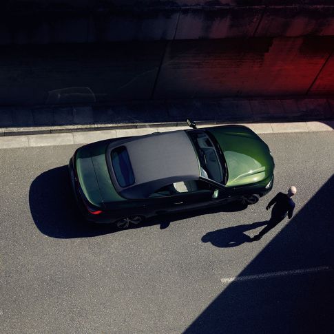 Bird's-eye view soft top BMW 4 Series Convertible G23 2020 with a man BMW 4 Series Convertible G23 2020 San Remo Green metallic bird's-eye view soft top with a man walking next to it