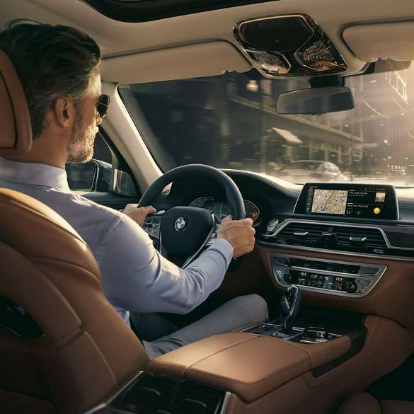 BMW 7 Series Sedan Connectivity features BMW 7 Series Sedan: man sits in BMW and uses Connectivity features