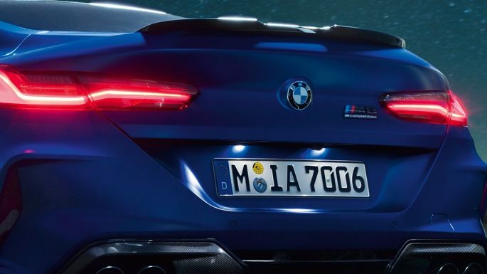 M diffuser in Carbon Black. BMW M8 Competition Coupé in Marina Bay Blue metallic, close-up rear at night with M diffuser in Carbon Black.