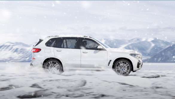 Driving mode xSnow BMW X5 G05 2018 Mineral White metallic side view driving on snow