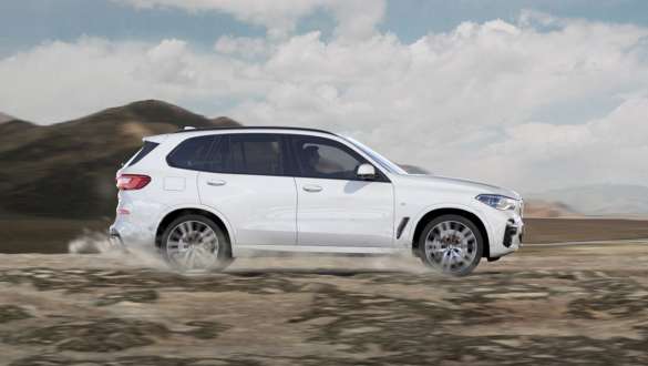 Driving mode xGravel BMW X5 G05 2018 Mineral White metallic side view driving on loose, stony ground
