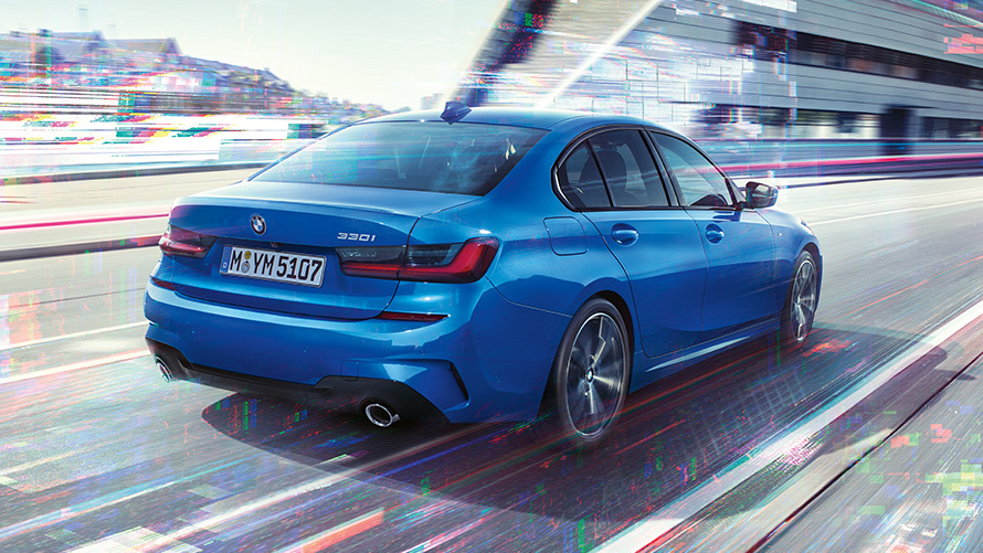 BMW 3 Series Saloon (G20), side rear shot. Three-quarter rear shot of the BMW 3 Series Saloon (G20) at day in front of an urban setting.