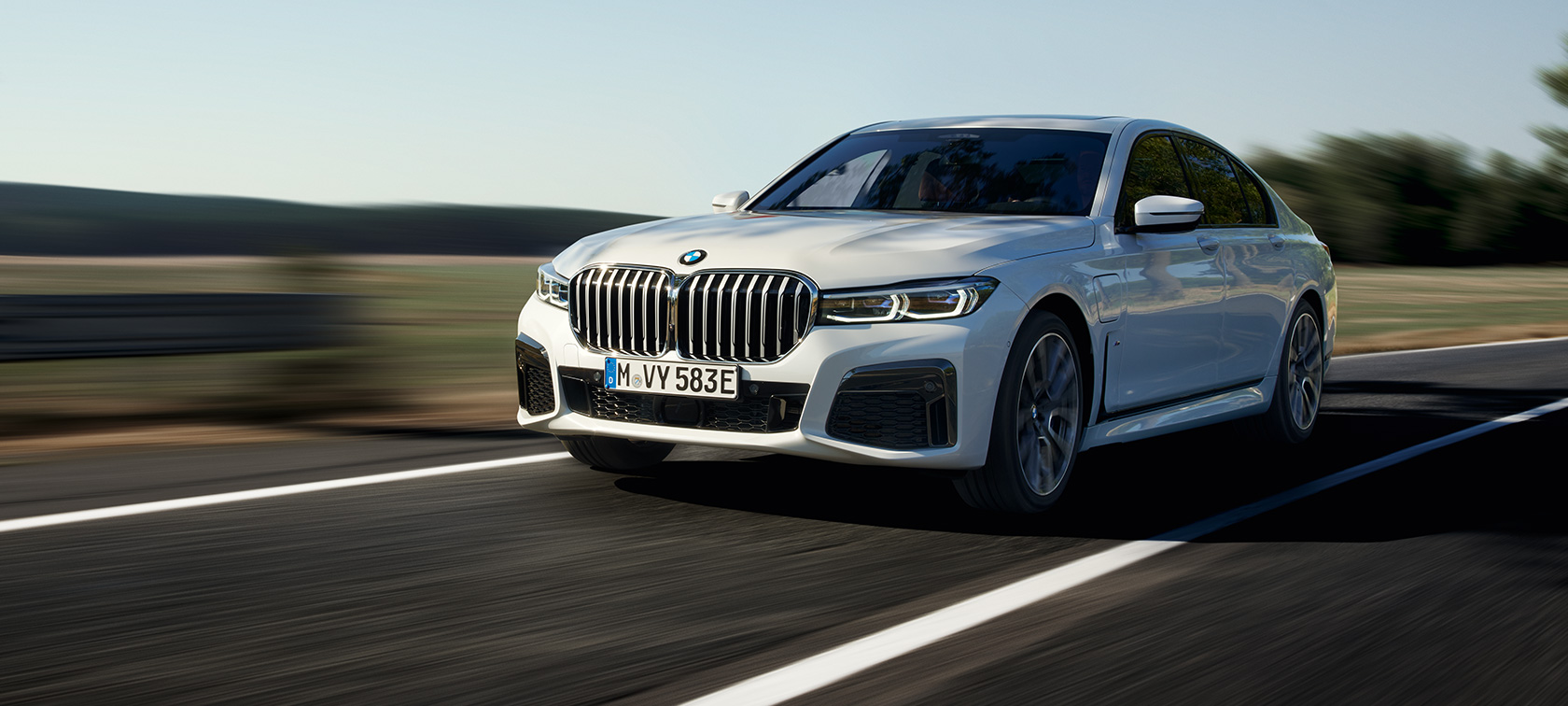 BMW 7 Series Saloon plug-in hybrid G11 G12 three-quarter front view driving BMW 7 Series Saloon plug-in hybrid G11 G12 three-quarter front view driving on the street