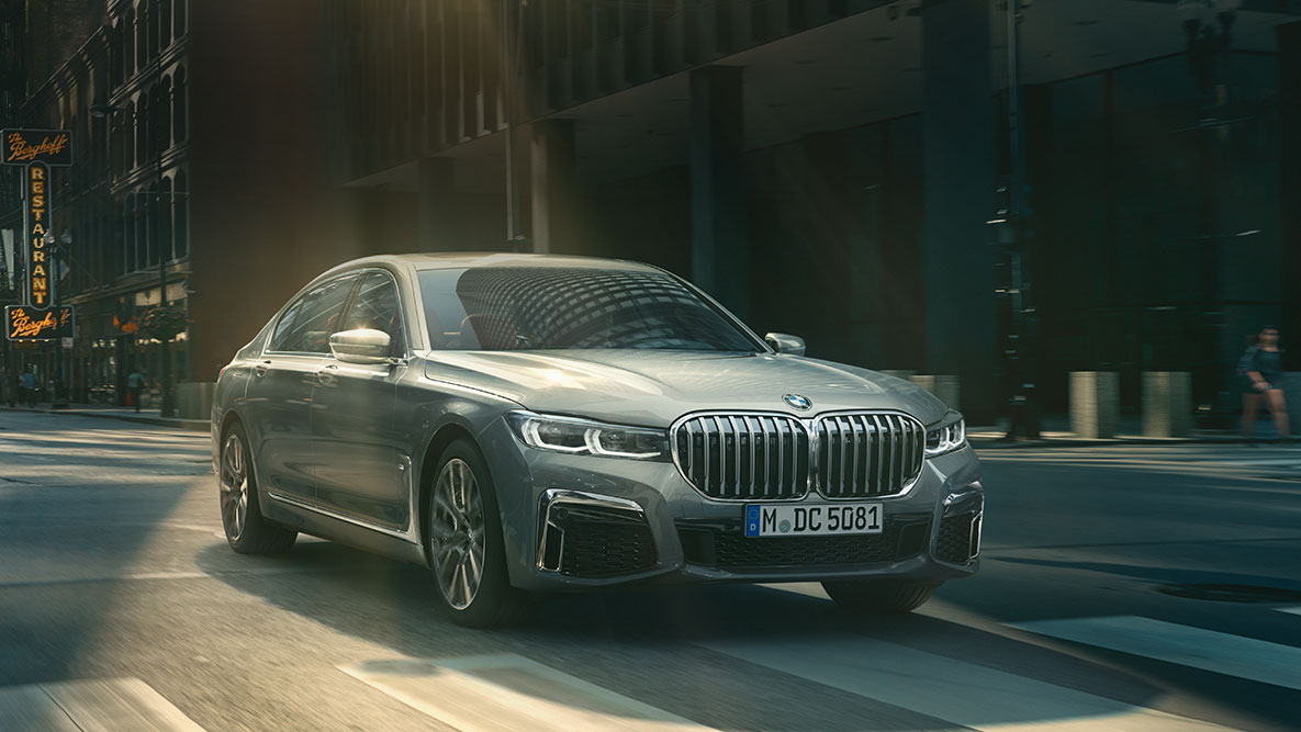Driving Assistant Professional: three-quarter front view of BMW 7 Series Saloon driving in front of urban setting BMW 7 Series Saloon Driving Assistant Professional