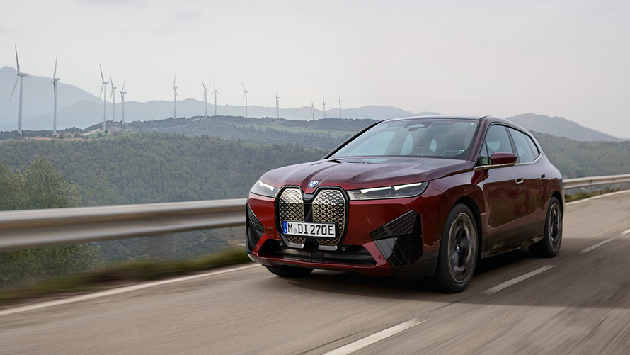 BMW iX xDrive50 i20 2021 electric SUV driving on coastal road sustainability