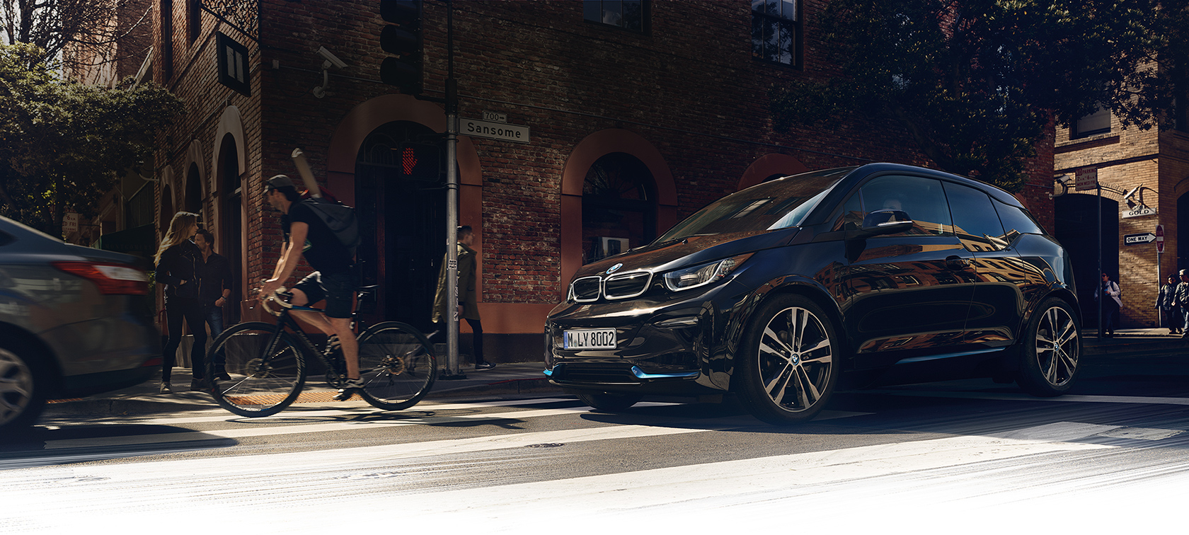 BMW i3s 2020 three-quarter front side-view in motion on road BMW i3s I01 2020 Fluid Black with Blue Highlight three-quarter front side-view in motion on road