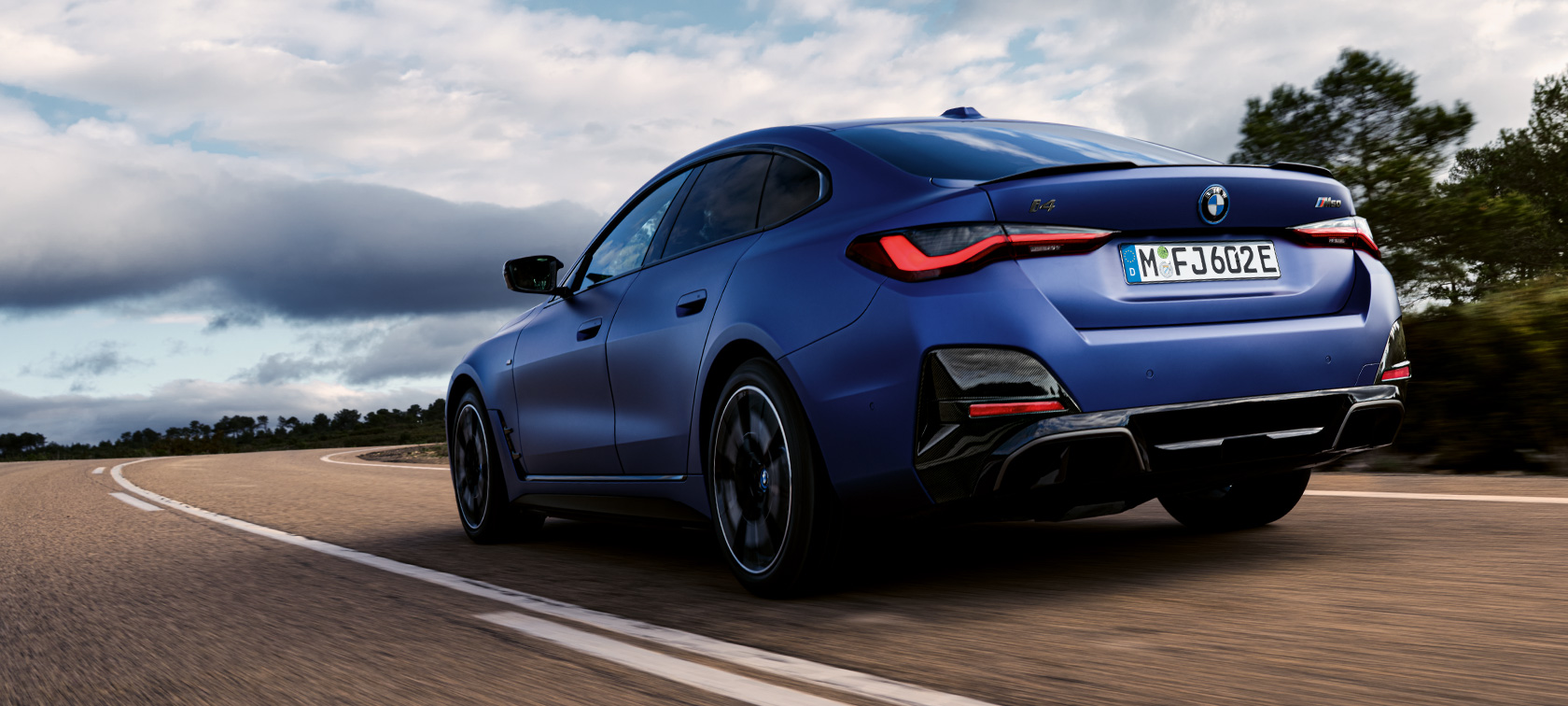 Three-quarter rear view BMW i4 M50 G26 2021 BMW i4 M50 G26 2021 BMW Individual Frozen Portimao Blue metallic three-quarter rear view driving