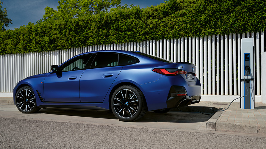 Side view BMW i4 M50 G26 2021 at a public fast-charging station BMW i4 M50 G26 2021 BMW Individual Frozen Portimao Blue metallic side view at a public fast-charging station