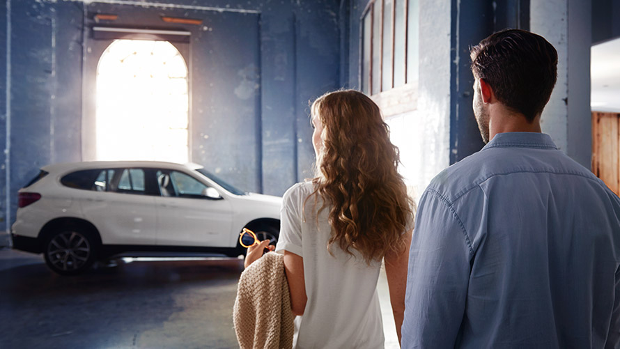 Father and son looking at BMW in retailer showroom