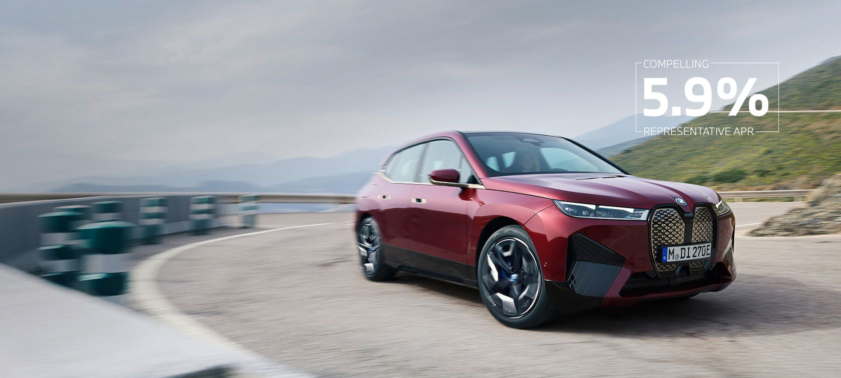 BMW iX i20 2021 electric SUV BMW iX xDrive50 Aventurin Red in front of coast