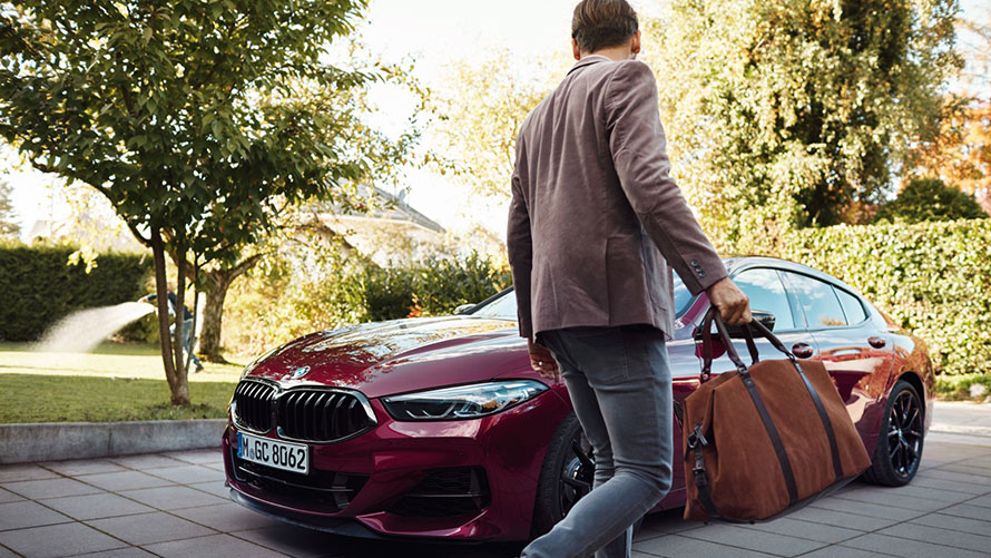 Man walking up to his BMW car in driveway Man walking up to his BMW car in driveway