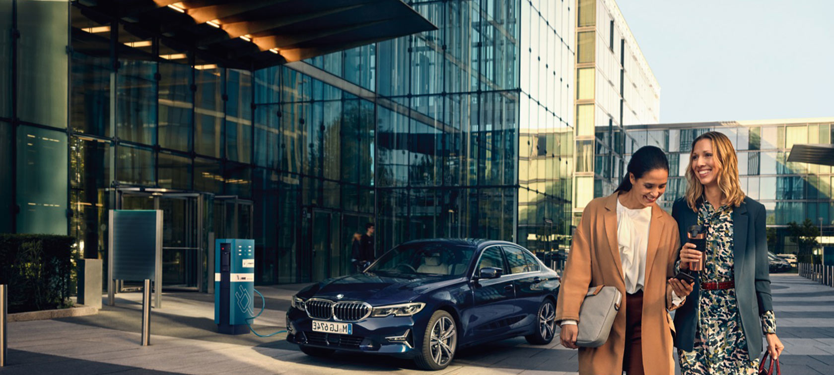 2 women with BMW car charging 2 women with BMW car charging