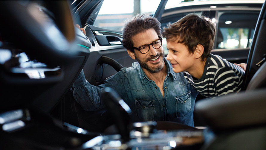 Men and boy looking at BMW interior