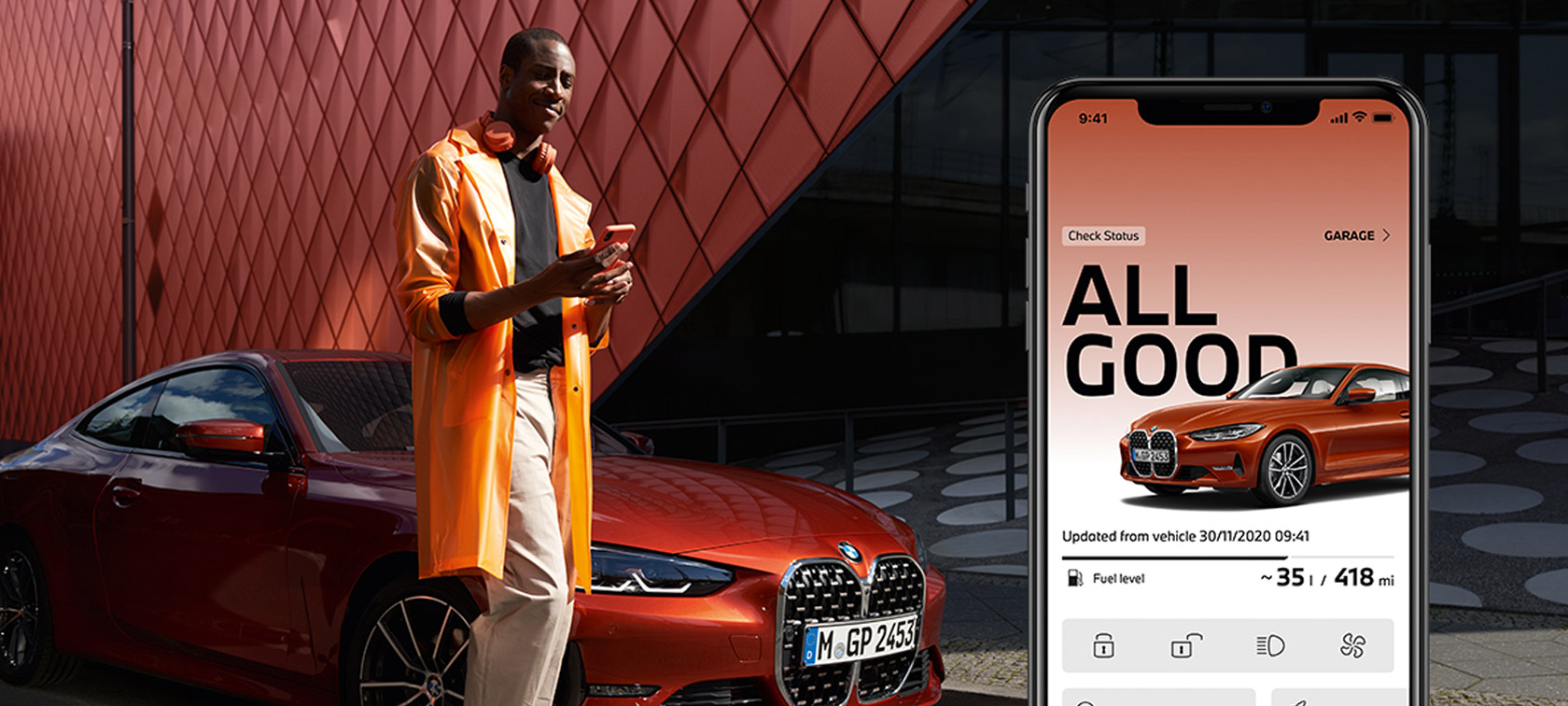 My BMW App Manage my status man using smartphone next to BMW My BMW App Manage my status man using smartphone next to BMW