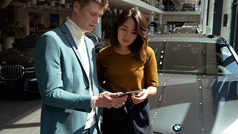 BMW consulting situation with two people BMW consulting situation with two people in front of BMW car