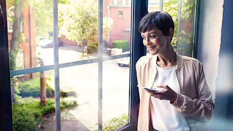 BMW ConnectedDrive FAQ BMW ConnectedDrive FAQ frequently asked questions woman with smartphone at the window
